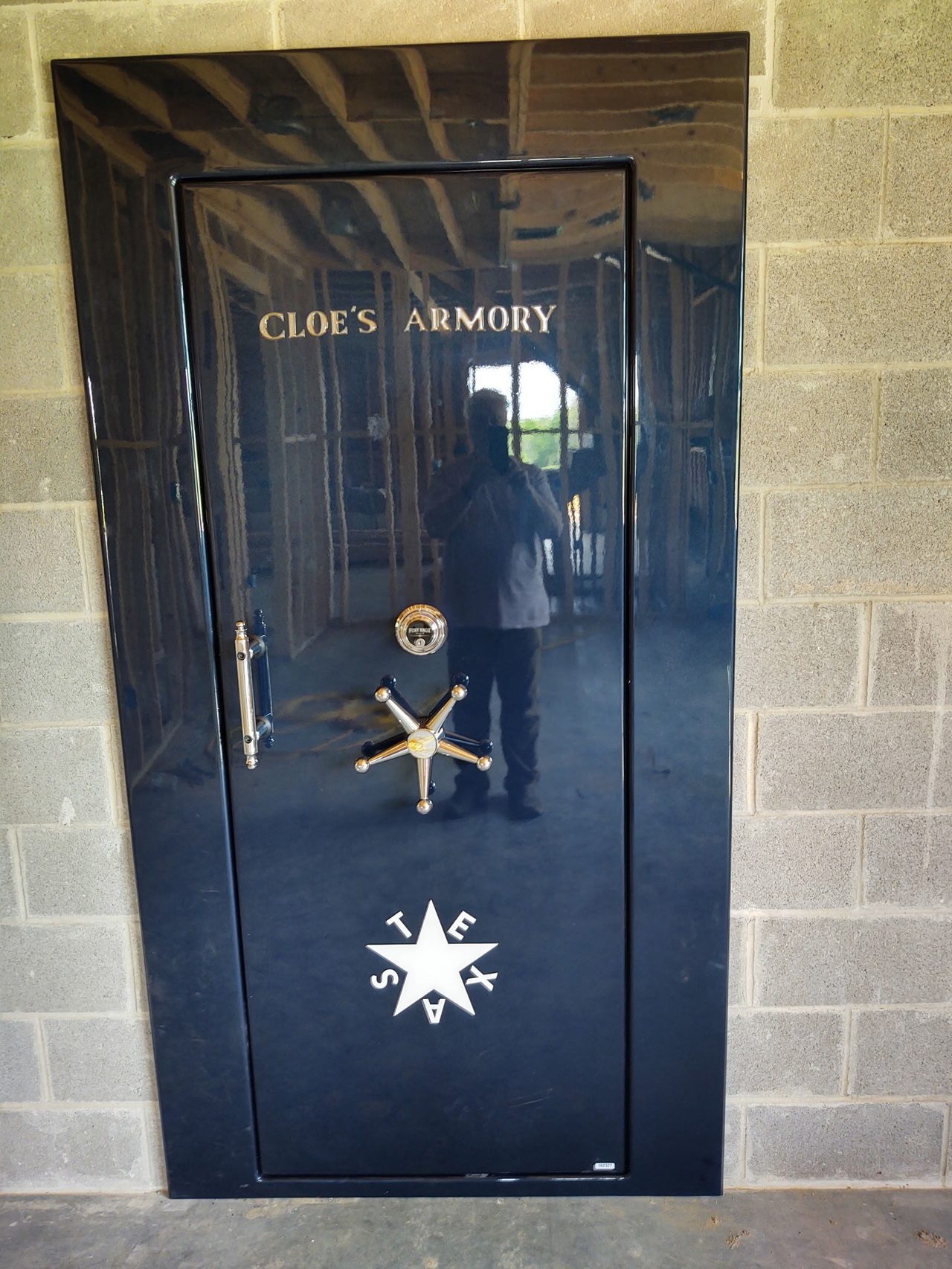 Black vault door with a Texas star inside the Alamo Wall barndominium, built by Cross Creek