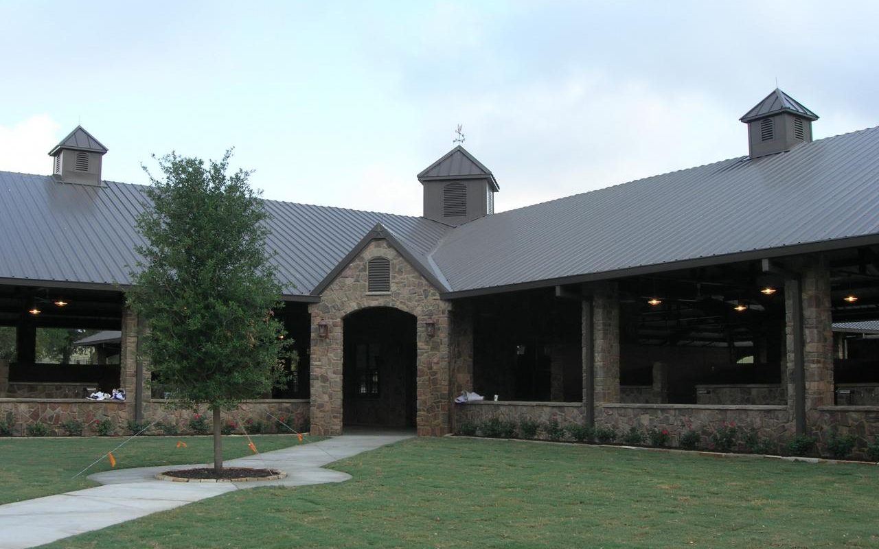 Polo Barn courtyard with stone archway and cupolas